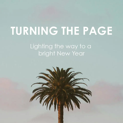 A single palm tree with the open sky at dusk in the background. The text reads: TURNING THE PAGE, Lighting the way to a bright New Year.