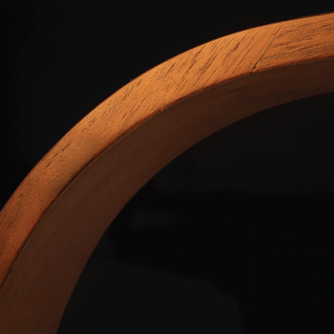 Close up of the wood on the Brooklyn LED Task Lamp with Black Walnut Wood finish. The image shows cross sections of real wood grain and the smooth curvature of the form factor.