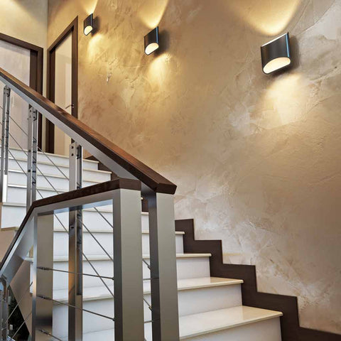 Three black slate Brooklyn LED wall sconces mounted in the stair case of a home