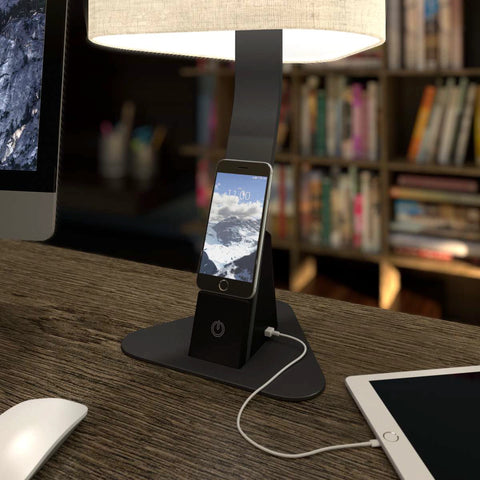 Brooklyn Aura LED Desk Lamp charging a smart phone on the 12 Watt Wireless Qi Charging Pad.There is also an iPad plugged into the USB-C port.