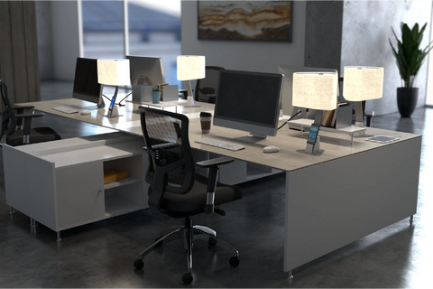 Brooklyn Aura LED Desk Lamps on a modern co-working desk. The lights are in Brushed Aluminum Finish