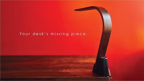 LUX Brooklyn LED Task lamp with Black Walnut finish on a wooden desk. Text reads "Your desk's missing piece."