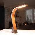 Brooklyn USB LED Task Light in Black Walnut Wood on a counter with a softly blurred background.
