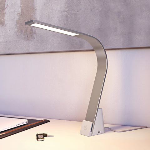 Side profile of Brooklyn USB LED Task Lamp in Brushed Aluminum next to a set of car keys on a minimalist desk with canvas art behind it.The USB-A port is visible as is the illuminated sleek LED panel.