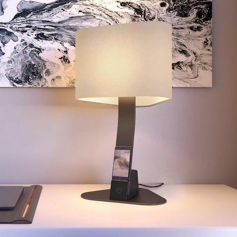 The Brooklyn Aura LED Desk Light by LUX LED Lighting, with a smartphone wireless charging on the device shelf.