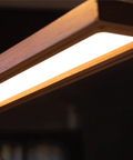 Close-up of the Brooklyn USB LED Task Light in Black Walnut Wood showing the warm illuminated LED panel and curved wood finish.