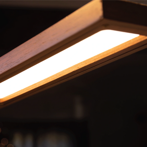 Close-up of the Brooklyn USB LED Task Light in Black Walnut Wood showing the warm illuminated LED panel and curved wood finish.