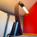 Brooklyn USB LED Task Light in Black Walnut Wood on a wooden surface with a red background.