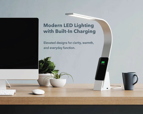 Modern Aluminum LED desk light charging a smartphone beside a computer on a home office desk.