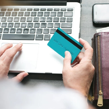 A person using a credit card to shop online, highlighting the ease and security of purchasing LUX LED products.