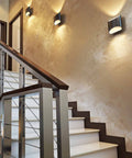 Three black slate Brooklyn LED wall sconces mounted in the stair case of a home 