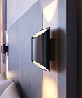 Two black slate Brooklyn LED wall sconces mounted on a headboard