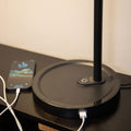 Close-up of the Highline USB LED Desk Lamp base with two USB-A charging ports and a phone charging